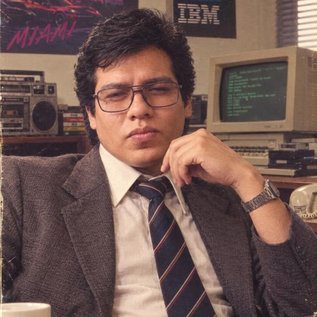 Retrato de Jorge Chávez en una oficina con computadoras